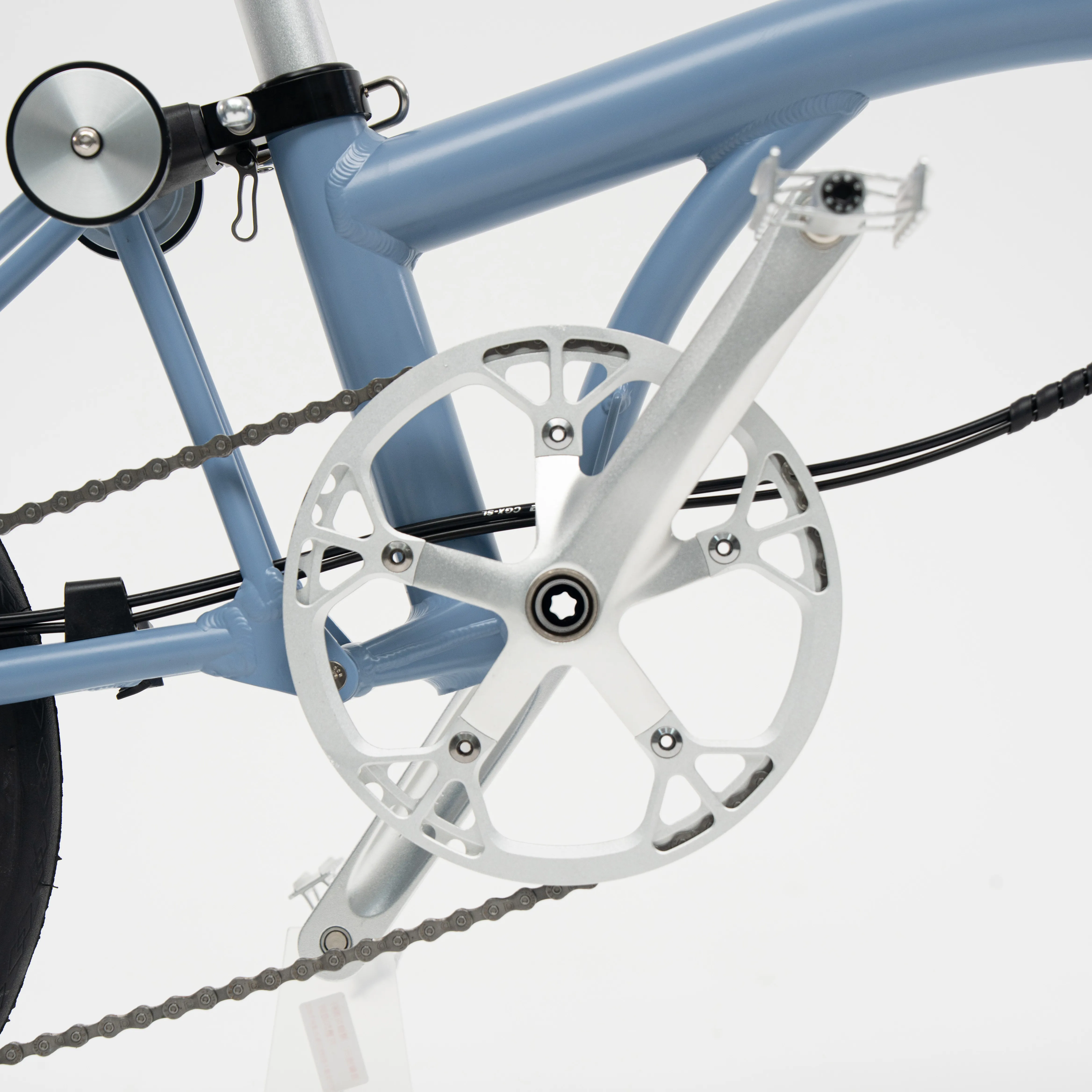 Lumio drivetrain detail — CNC hollow five-arm crankset and 50T chainring, Cloud Blue frame