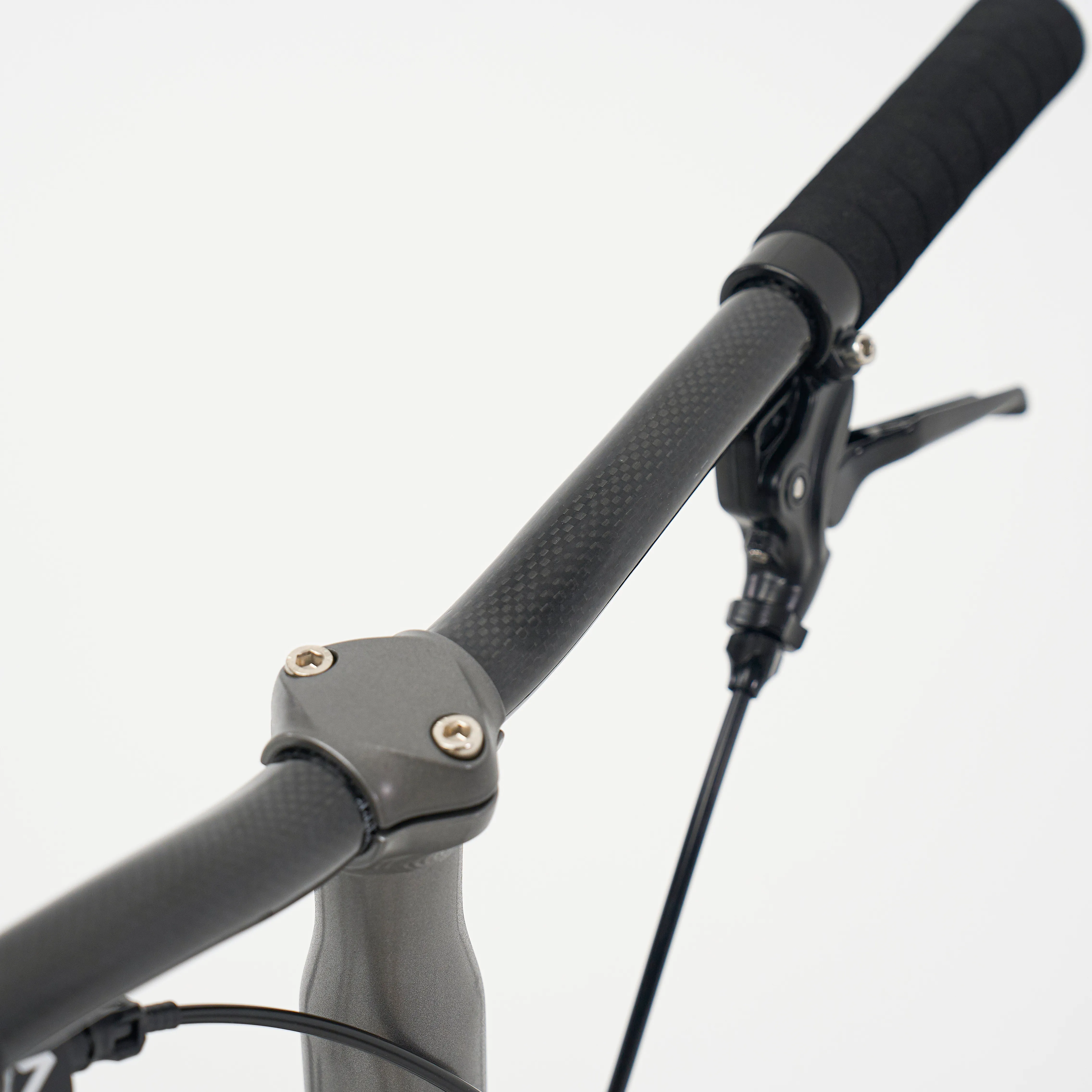 Aerra cockpit detail — H30 carbon-fibre S-bar with 31.8 mm clamp and JAGWIRE hydraulic cabling