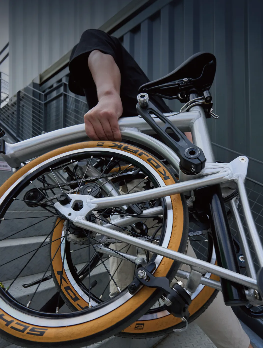 A commuter carrying a folded LMile bike through a station stairwell