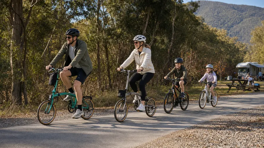 A family of four riding LMile folders together along a sunny rail trail.